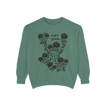Green sweatshirt with rose floral graphic and “Let’s grow” typography, soft cotton blend