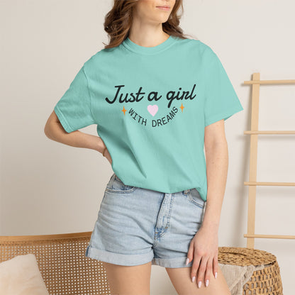 Woman wearing a light blue t-shirt with 'Just a girl WITH DREAMS' text and a pink heart.