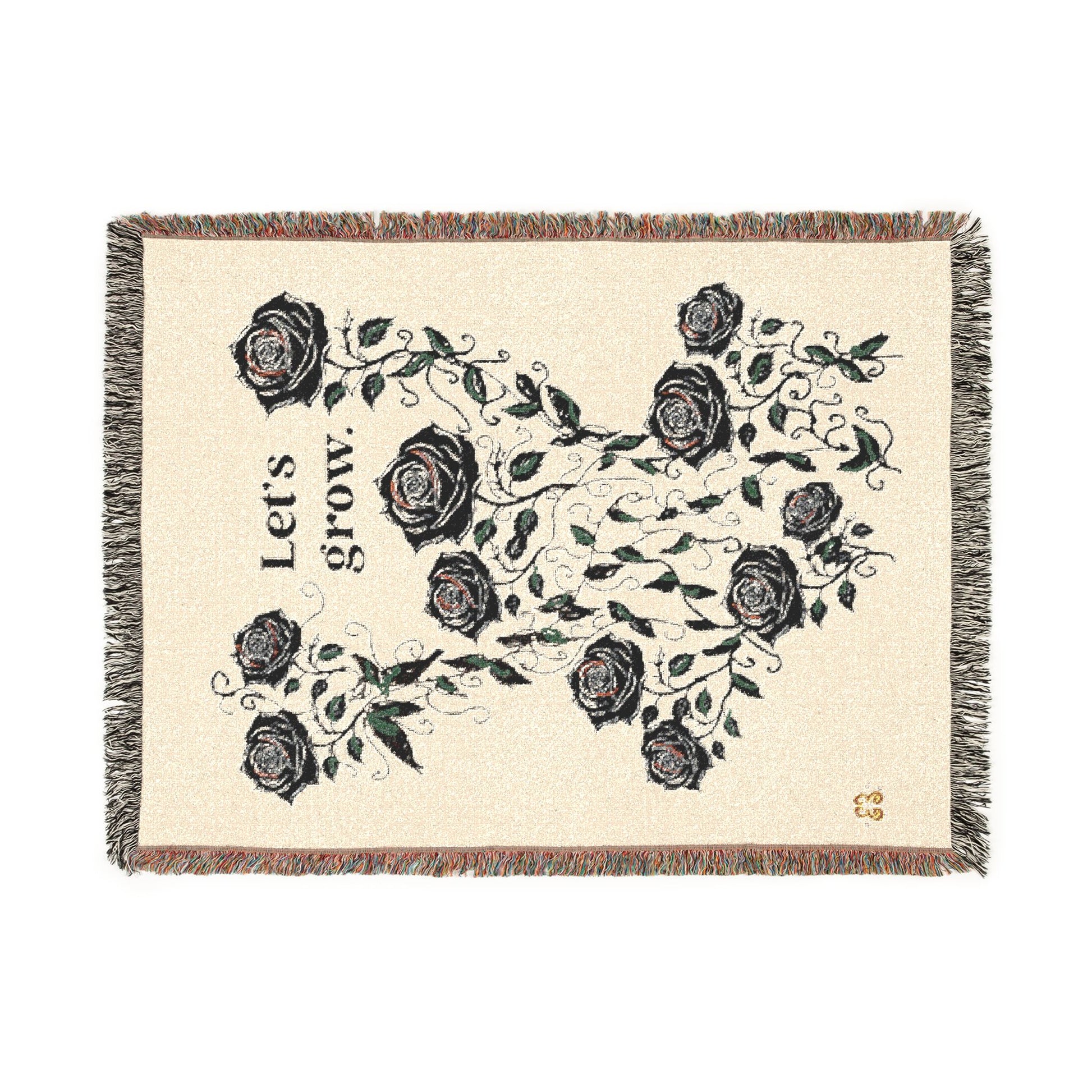 Beige floral throw blanket with black rose pattern and tassel fringe, cozy woven fabric