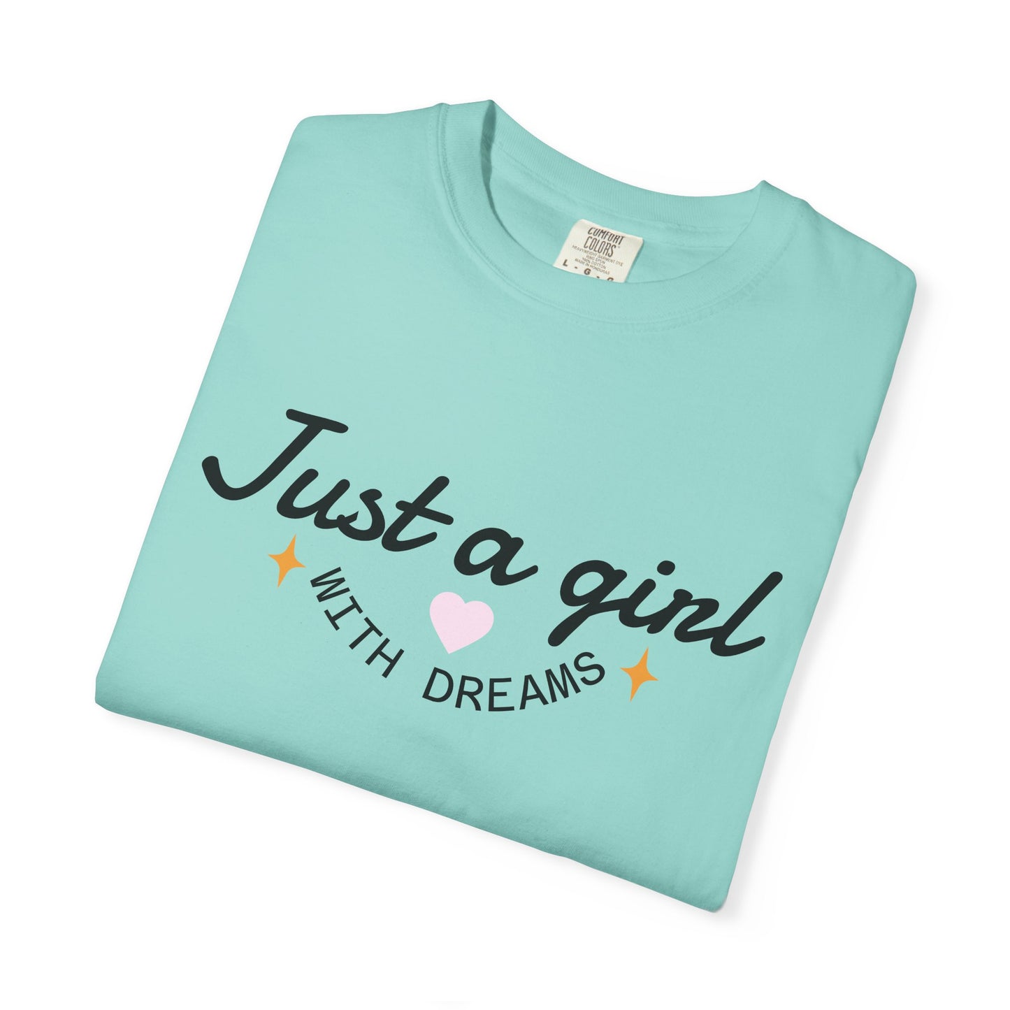 Light blue t-shirt featuring the text 'Just a girl WITH DREAMS' with a pink heart and stars.