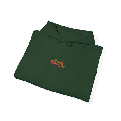 Forest green hoodie, “Slut” chest logo, drawstring hood, laid flat