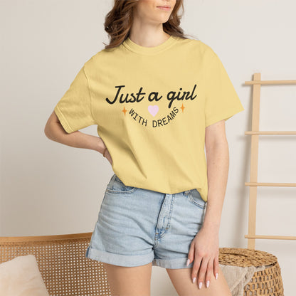 Woman wearing a yellow t-shirt with 'Just a girl WITH DREAMS' text and a pink heart.